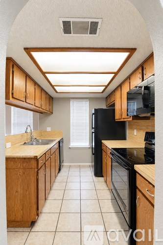 A kitchen with wooden cabinets and black appliances.