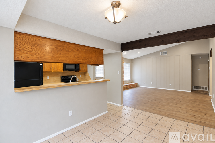 A living room with a kitchenette and a door to another room.