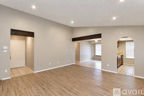 A spacious room with wooden floors and white walls.