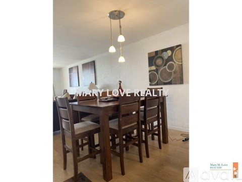 A dining room with a wooden table and chairs.
