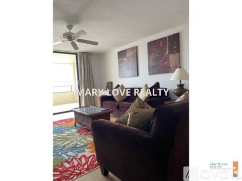 A living room with a brown chair and a painting on the wall.