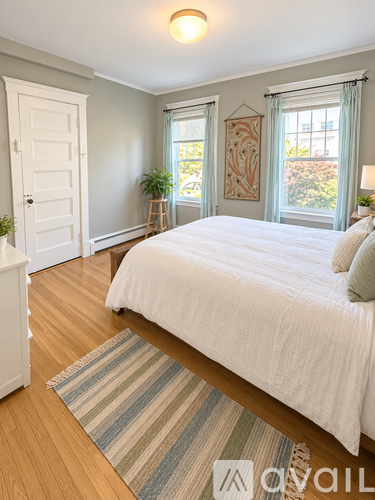 A bedroom with a large bed and a wooden floor.