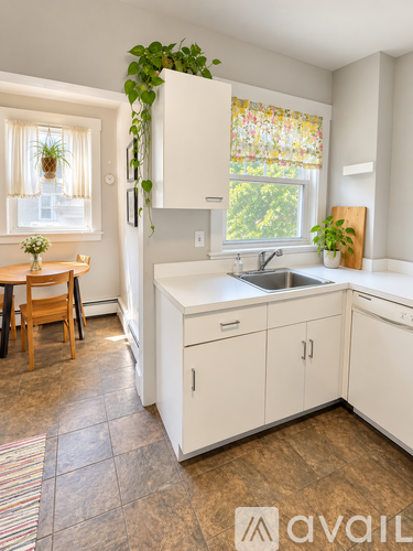 A kitchen with white cabinets and a wooden table.