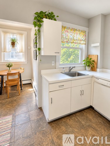 A kitchen with white cabinets and a wooden table.