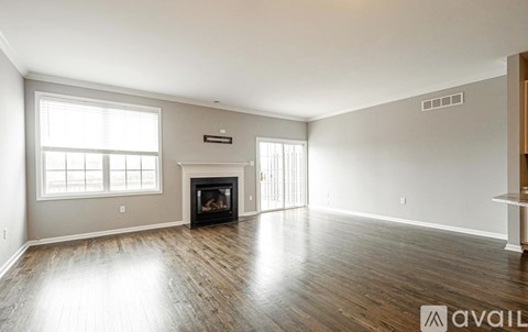 A spacious living room with a fireplace and wooden flooring.