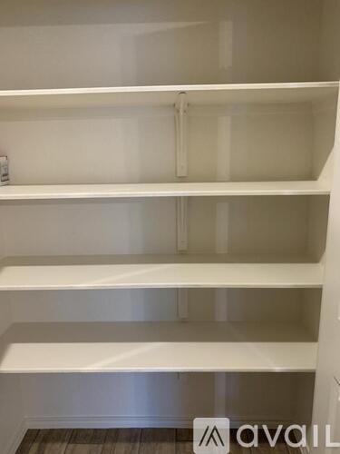 A white shelving unit with four shelves is shown.