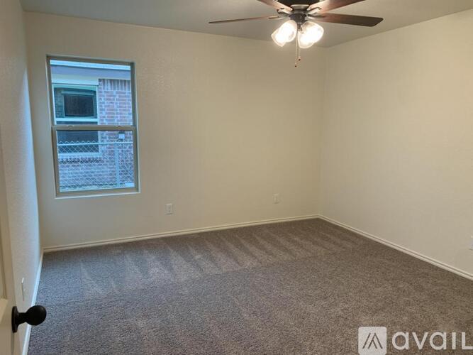 A room with a ceiling fan and carpeted floor.
