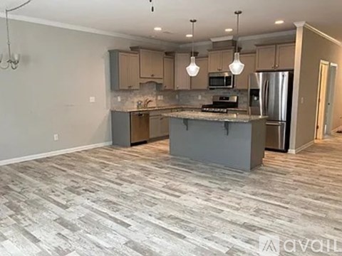 A kitchen with a grey island and wooden cabinets.