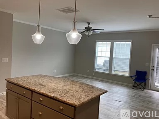 A kitchen with granite countertops and a ceiling fan.