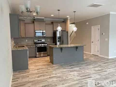 A kitchen with a large island and a stove top oven.