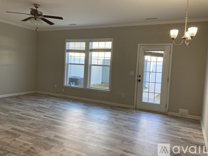 A spacious room with a ceiling fan and a chandelier.