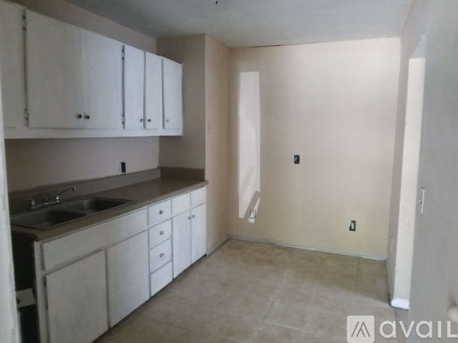 A kitchen with white cabinets and a sink.