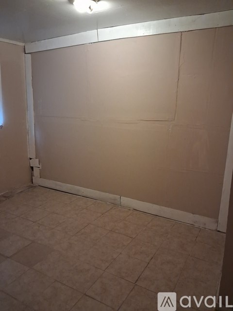 A room with beige walls and tiled floor.