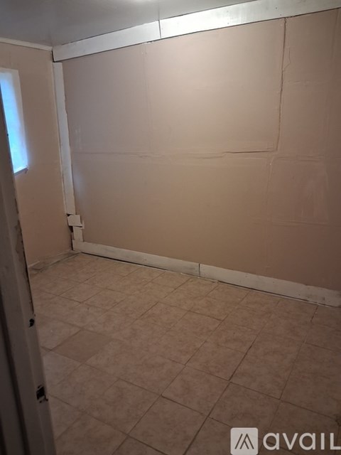A room with beige walls and tiled floor.