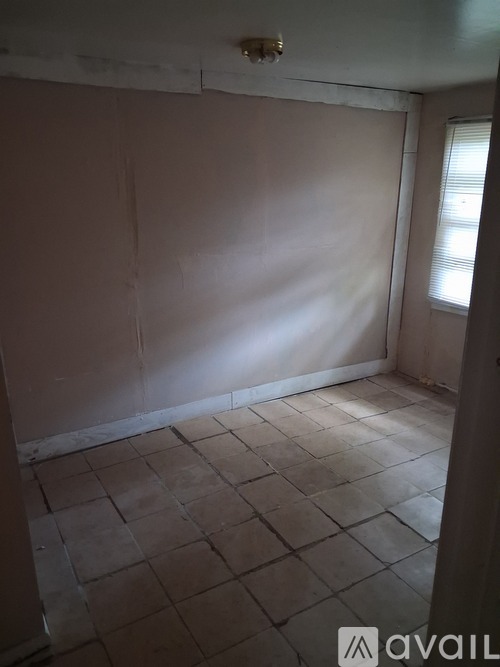 A room with tiled flooring and a window letting in light.