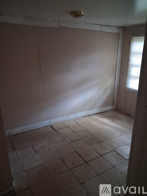 A room with tiled flooring and a window letting in light.