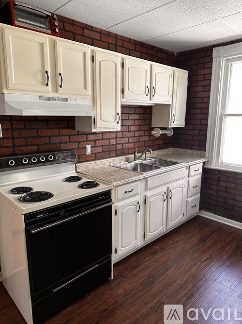 A kitchen with white cabinets and a black stove top oven.