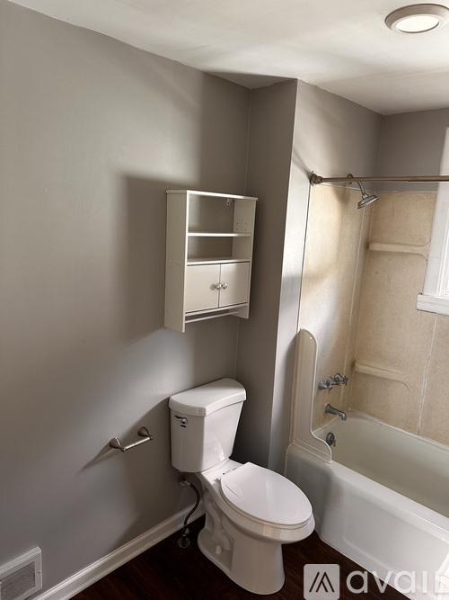 A white toilet with a cabinet above it in a bathroom.