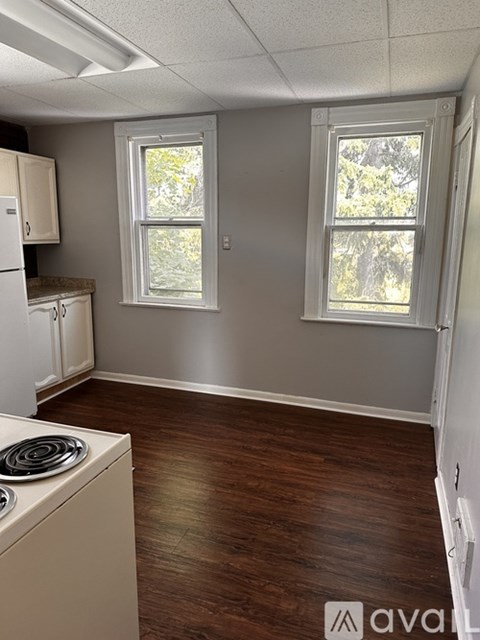 A kitchen with wood floors and white appliances.