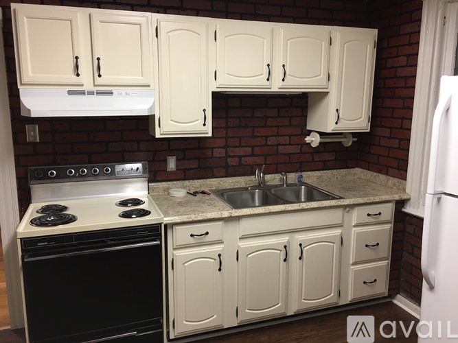 A kitchen with white cabinets and a black stove top oven.