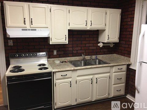 A kitchen with white cabinets and a black stove top oven.