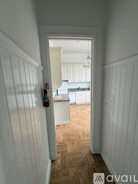 A hallway with a doorway leading to a kitchen.