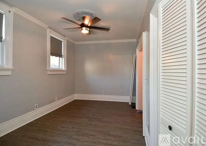 A room with a ceiling fan and a window.