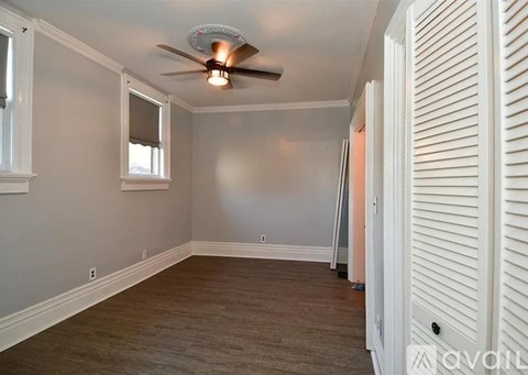 A room with a ceiling fan and a window.