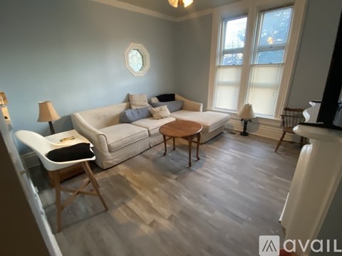 A living room with a white couch and a wooden coffee table.
