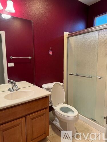 A bathroom with a toilet, sink, and shower.