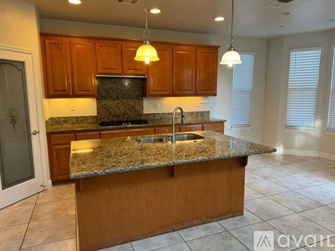 A kitchen with granite countertops and wooden cabinets.
