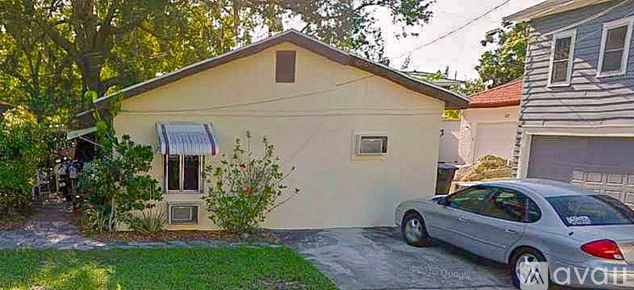 A small house with a car parked in front.