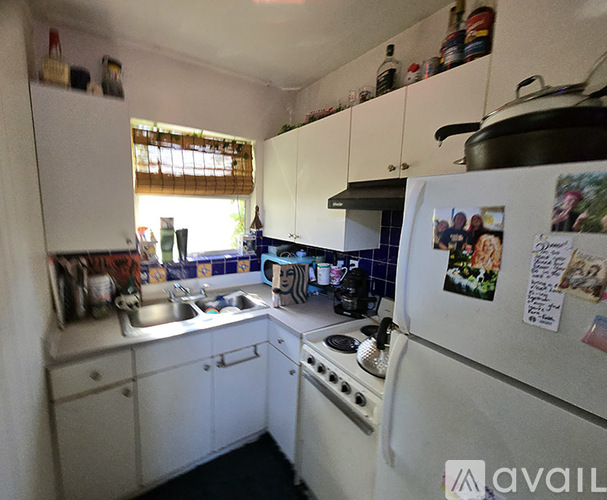A small white kitchen with a refrigerator, sink, and stove.