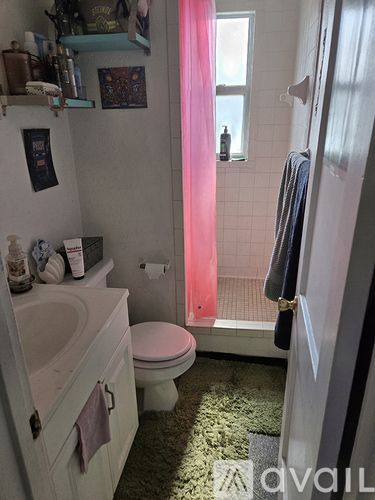 A bathroom with a toilet, sink, and shower.