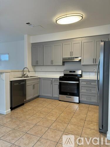 A kitchen with a black refrigerator and a black dishwasher.