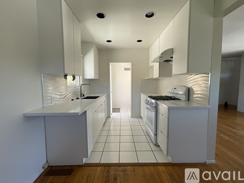 A modern kitchen with white cabinets and a central island.