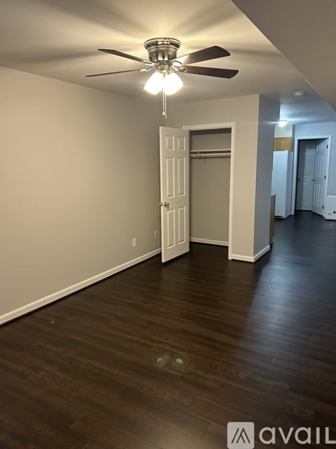 A room with a ceiling fan and wooden flooring.