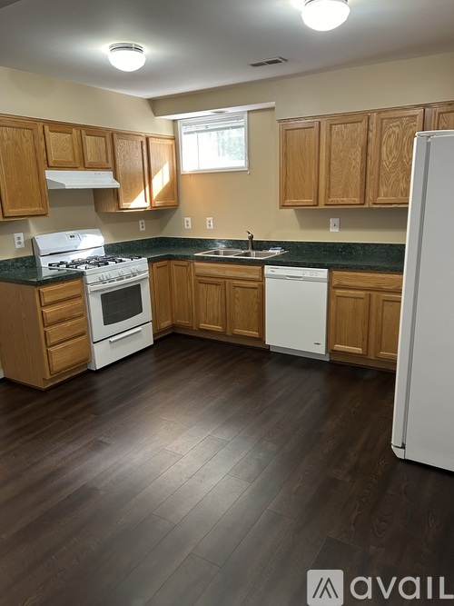 A kitchen with wooden cabinets and a white refrigerator.