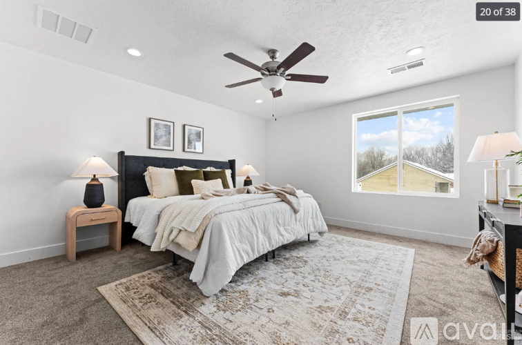 A bedroom with a large bed and a ceiling fan.