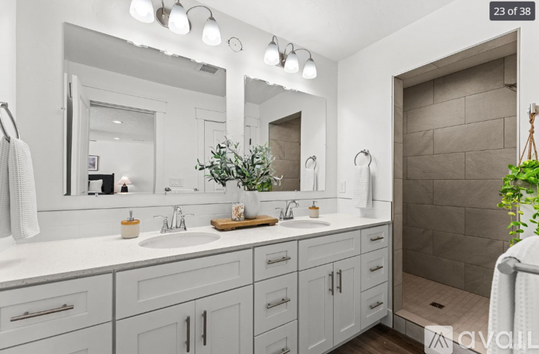 A modern bathroom with a white countertop and a large mirror above the sink.