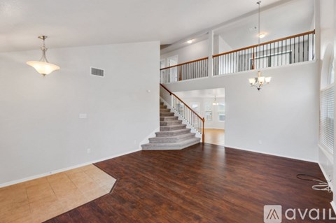 A spacious living room with a staircase leading to the upper floor.