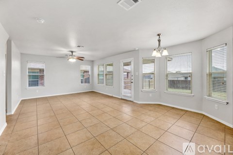 A spacious room with tiled flooring and a ceiling fan.