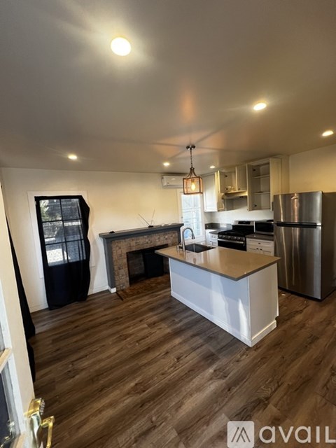 A kitchen with a wooden floor and a white island.