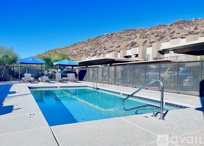 A pool with a slide and a mountain in the background.