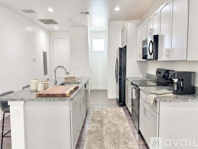 A kitchen with white cabinets and a granite countertop.