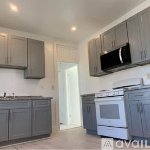 A kitchen with grey cabinets and a white oven.