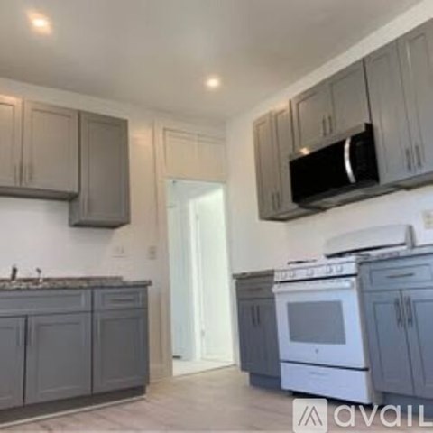 A kitchen with grey cabinets and a white oven.