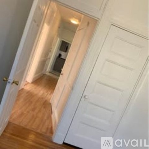 A hallway with a white door and a white door frame.
