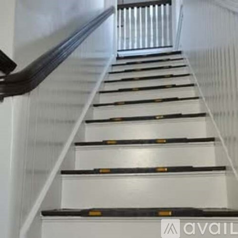 A staircase with black handrails and white steps.