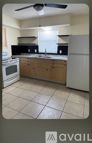 A kitchen with a white refrigerator, white stove, and white oven.